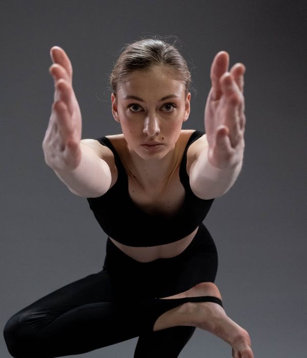 Young woman practicing yoga in a dark studio with soft lighting